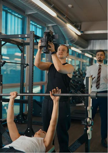 Kameramann filmt eine Trainingsszene im Fitnessstudio