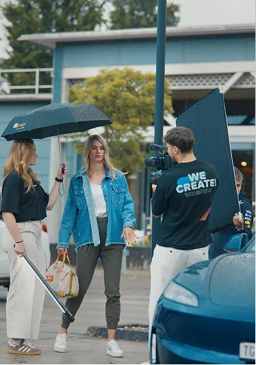 Dreh auf dem Parkplatz mit Regenschirm, Softbox und Darstellerinnen