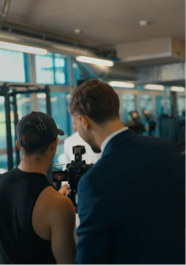 Kameramann und Teammitglied beim Dreh im Fitnessstudio