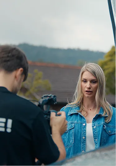 Darstellerin in Jeansjacke im Gespräch mit dem Kameramann