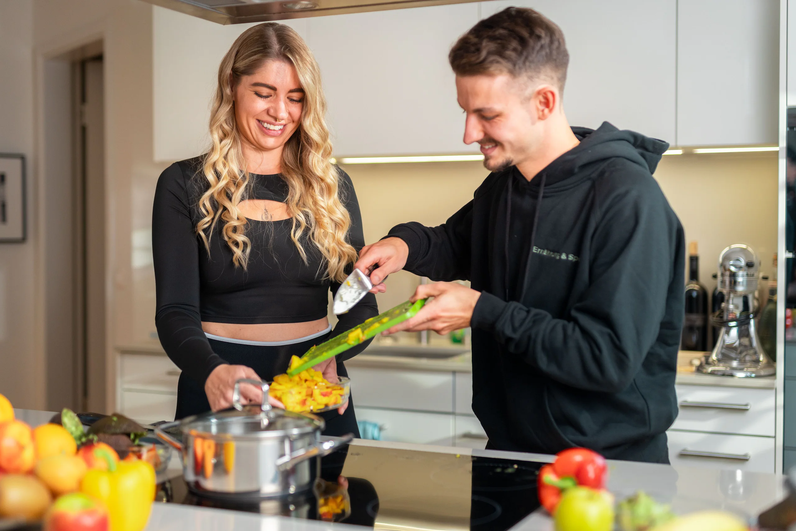 Ernährungscoach und Kundin bereiten gemeinsam Gemüse in der Küche zu