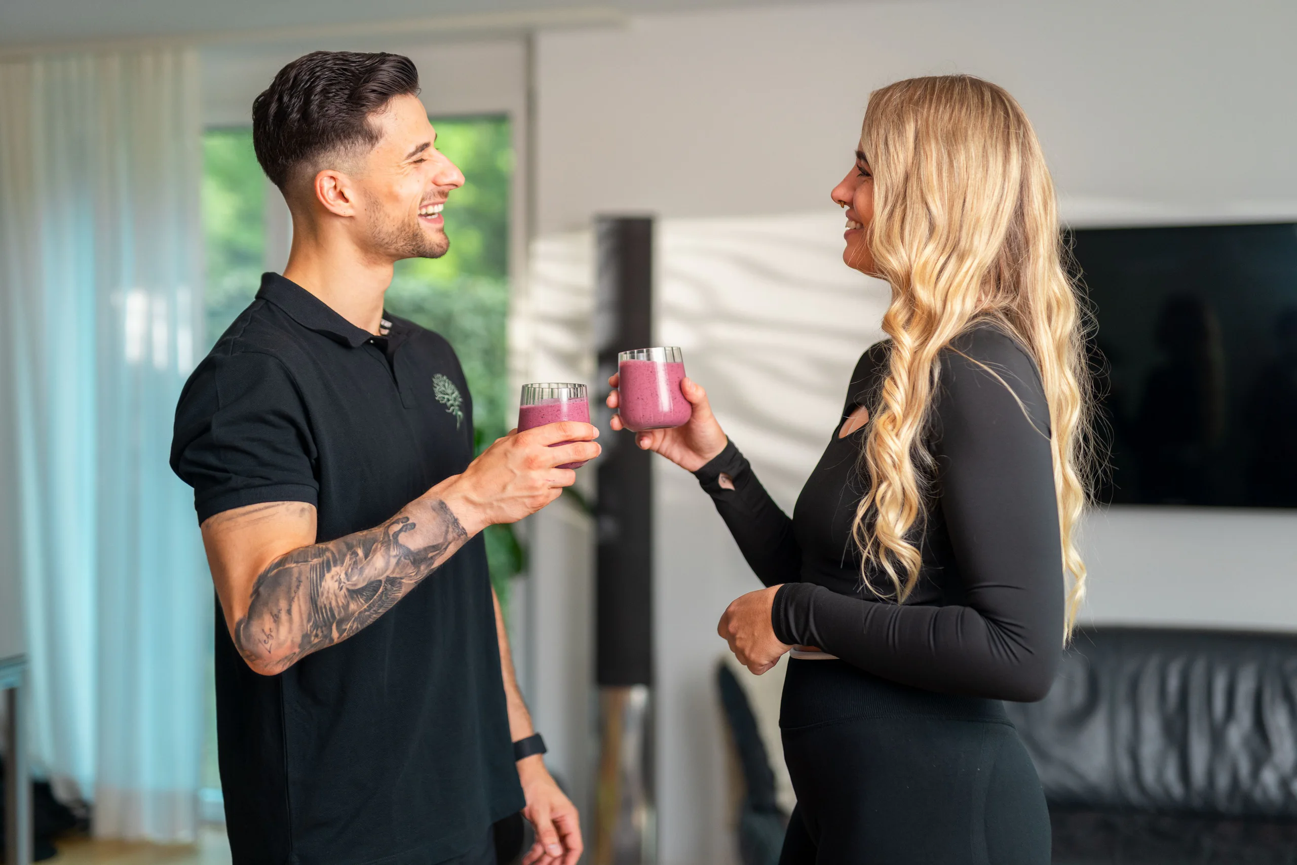 Coach und Kundin stossen mit einem Proteinshake an