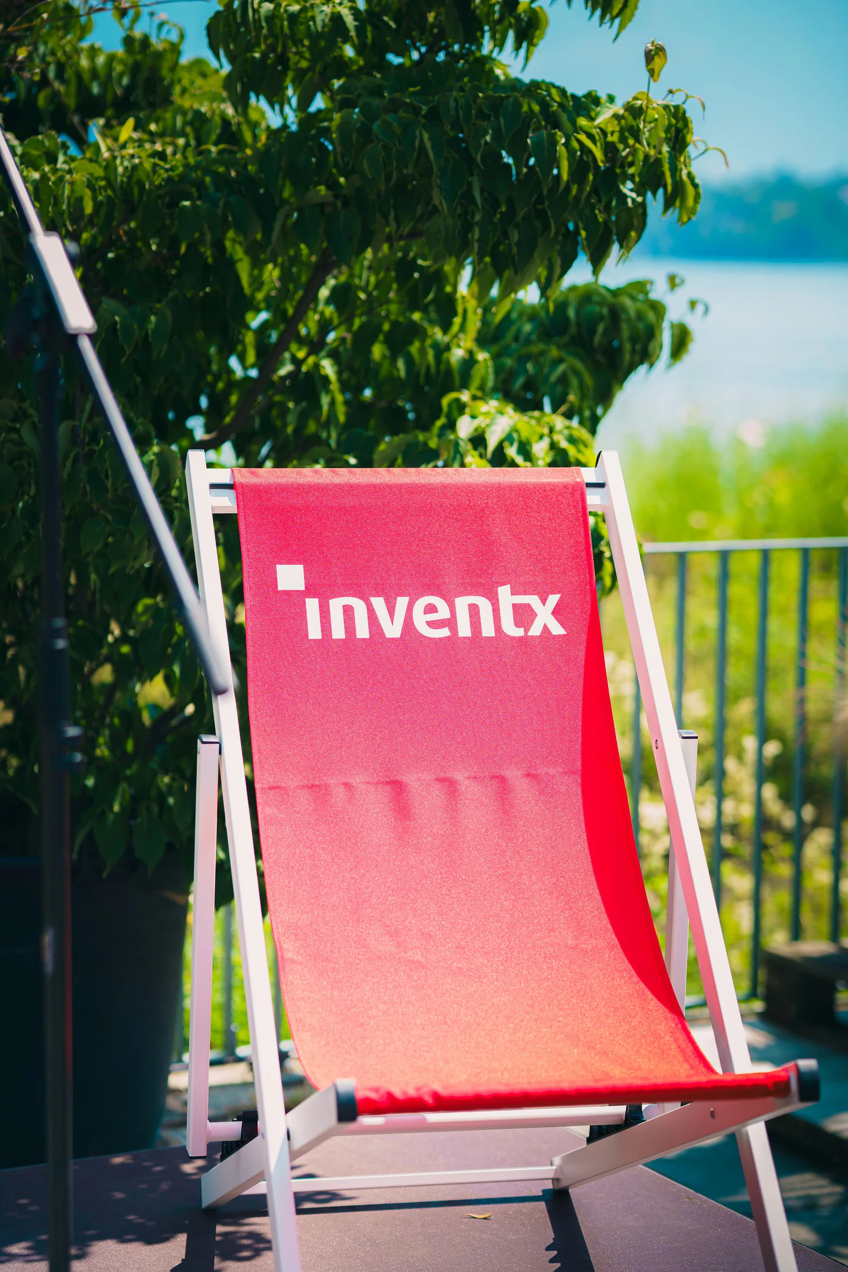 Roter InventX-Liegestuhl auf der Terrasse am See