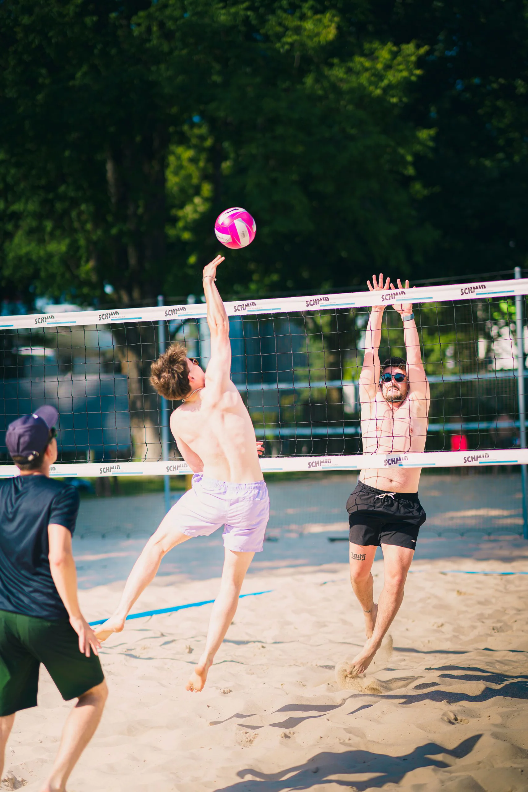 Beachvolleyball-Spieler springen am Netz