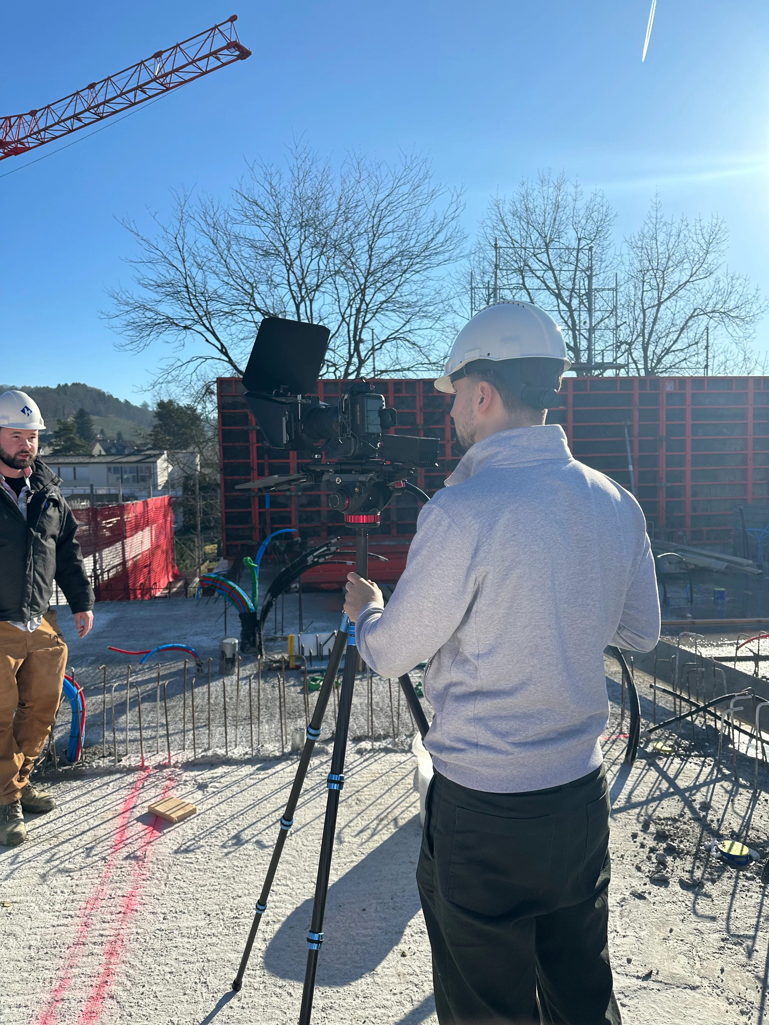 Dreh auf der Baustelle mit Stativ und Bauhelm